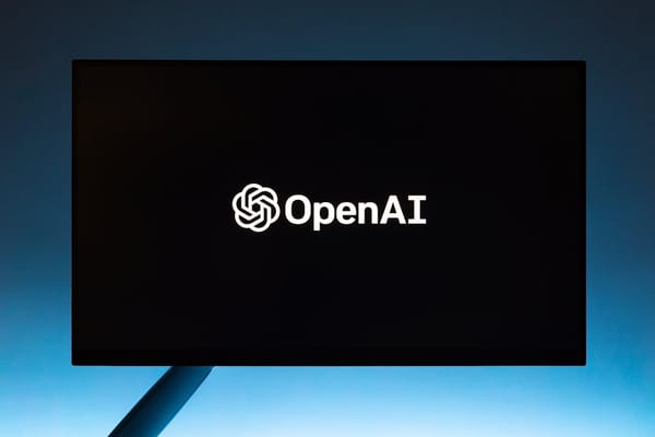 A computer screen displaying the OpenAI logo against a dark background with a blue gradient