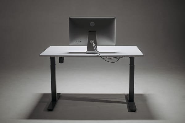 A minimalist setup featuring a standing desk and a computer monitor