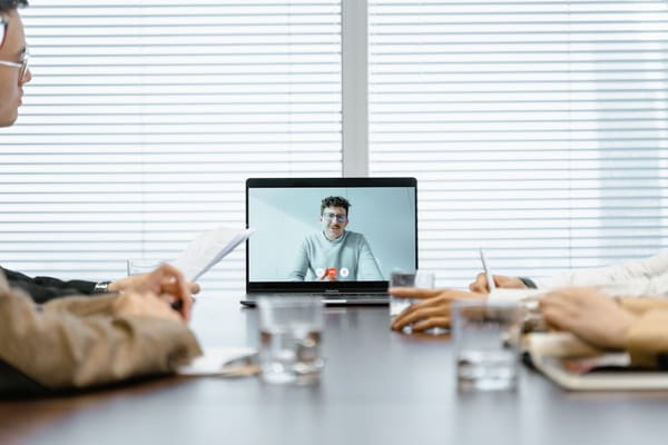 A group of people is seated around a conference table in a business setting