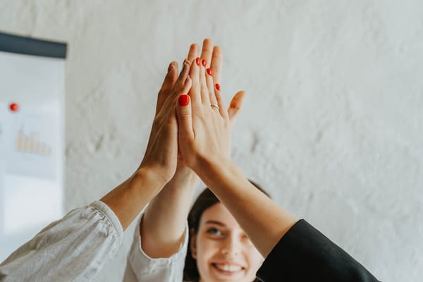 A group of people giving a high-five together in an office setting