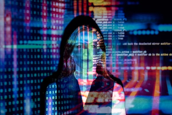 A woman stands in front of a screen with colorful projections of binary numbers and code, symbolizing technology and digital themes