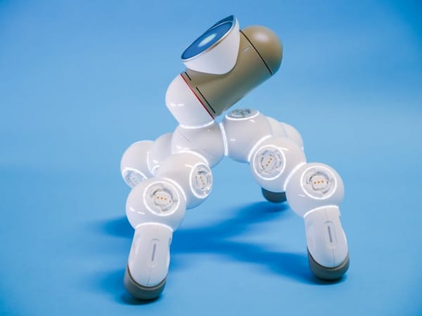 A futuristic-looking robot with a sleek design, featuring multiple jointed segments and a blue and white color scheme, set against a plain blue backgr