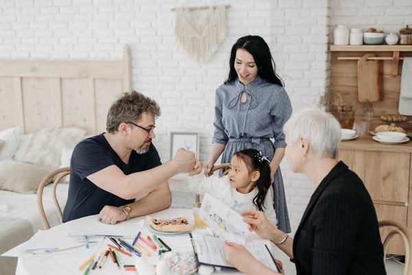 A family gathering around a table, engaged in an art activity