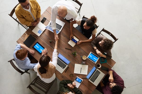 An overhead view of a diverse group of people engaged in a business meeting around a large wooden table