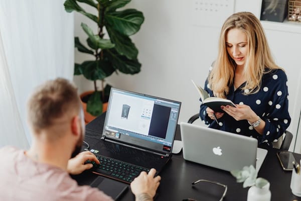 A man and a woman are working at a desk