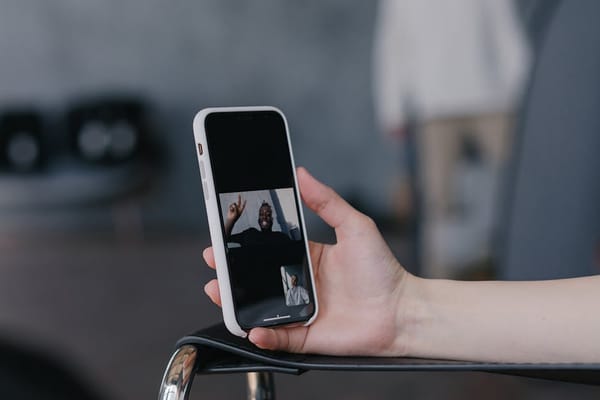 A close-up image of a person holding a smartphone showing a video call