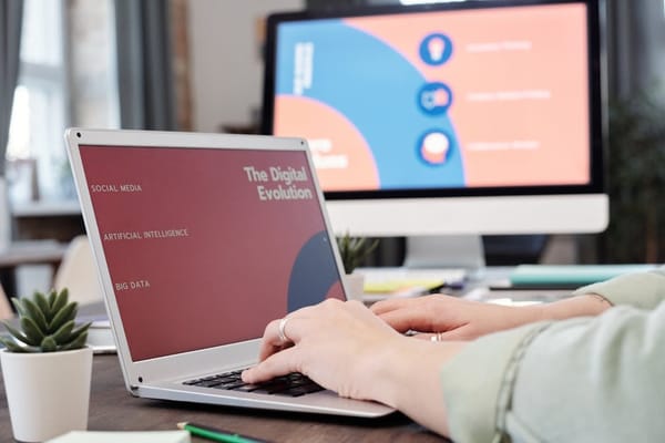 A person using a laptop with a presentation on 'The Digital Evolution' displayed on the screen