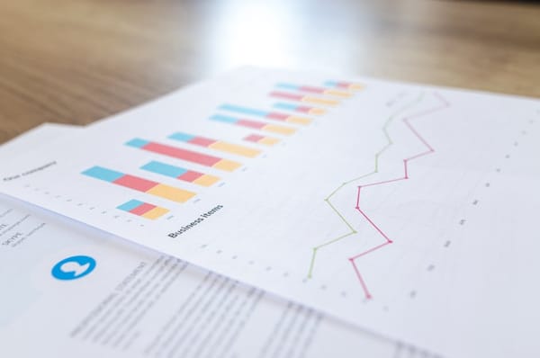 The image features a close-up view of a document displaying business-related graphs and charts