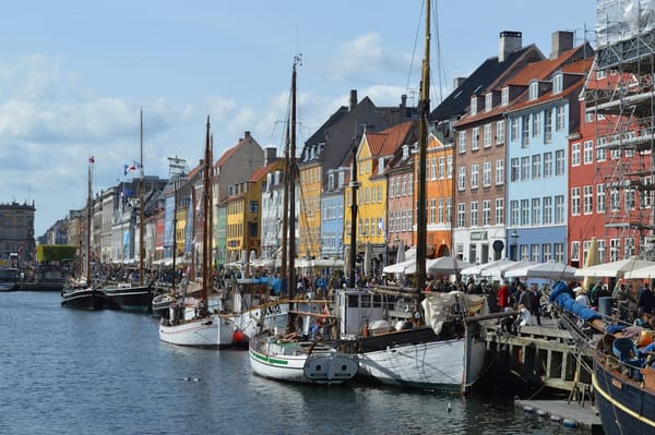 The image captures a scenic view of a harbor lined with colorful historic buildings